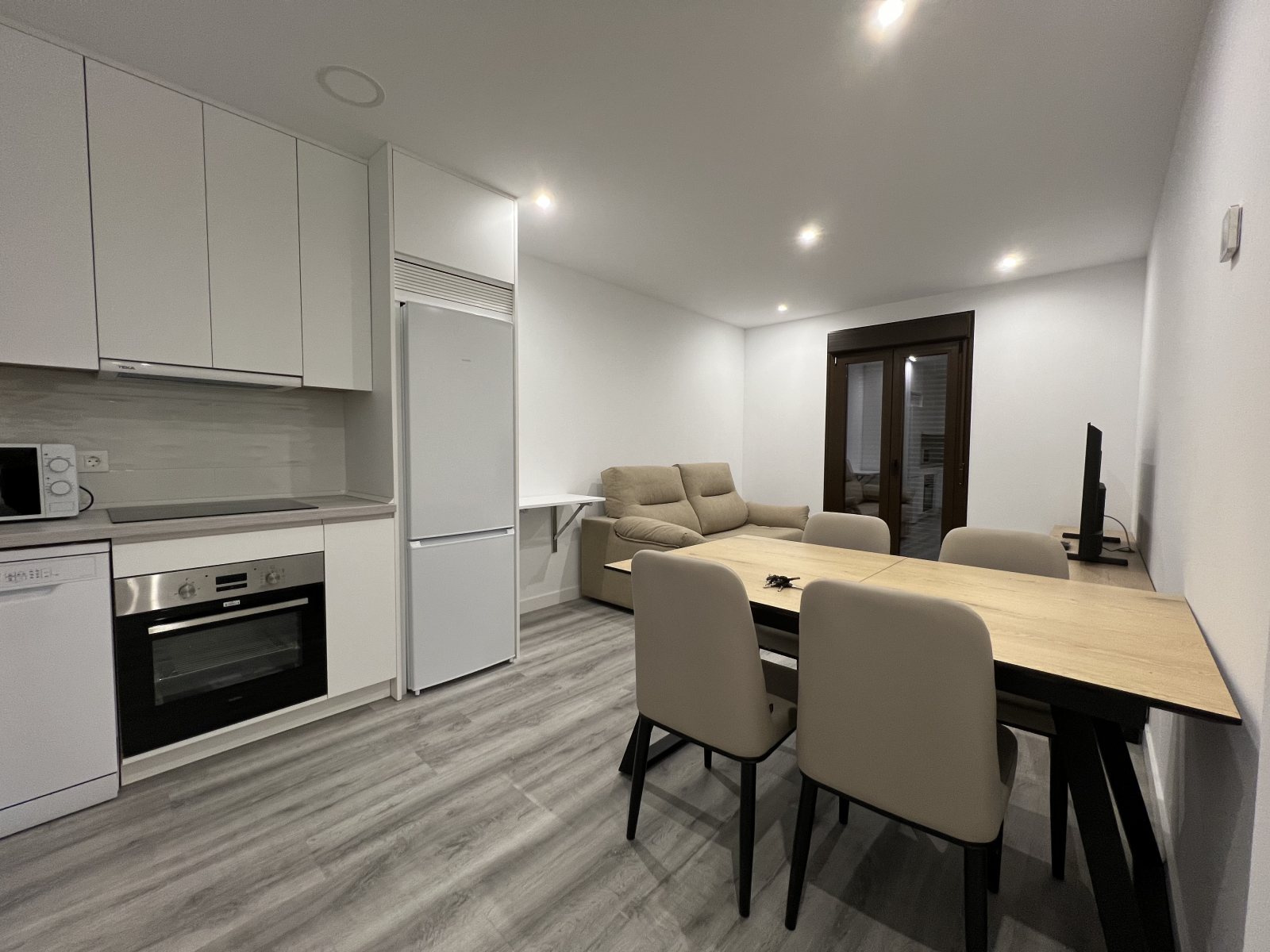 Salón y cocina abierta de una vivienda tras la reforma integral