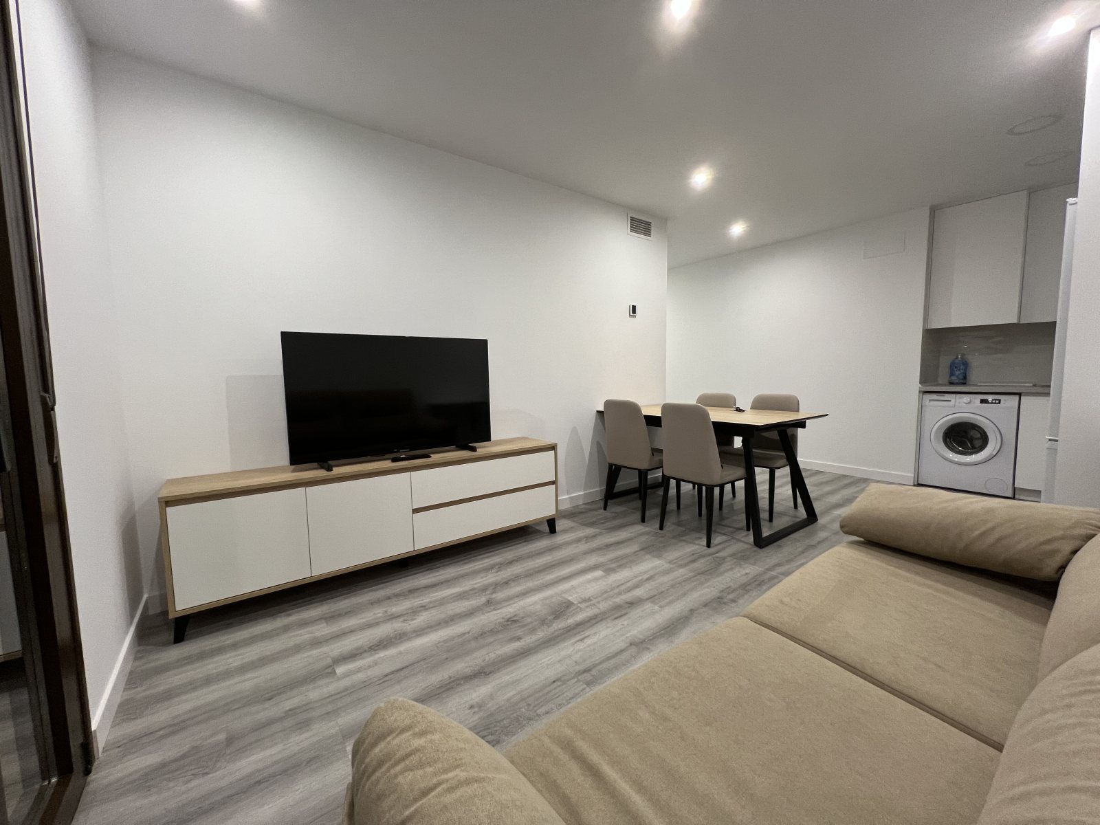 Salón y cocina de una vivienda reformada íntegramente por Patrimes